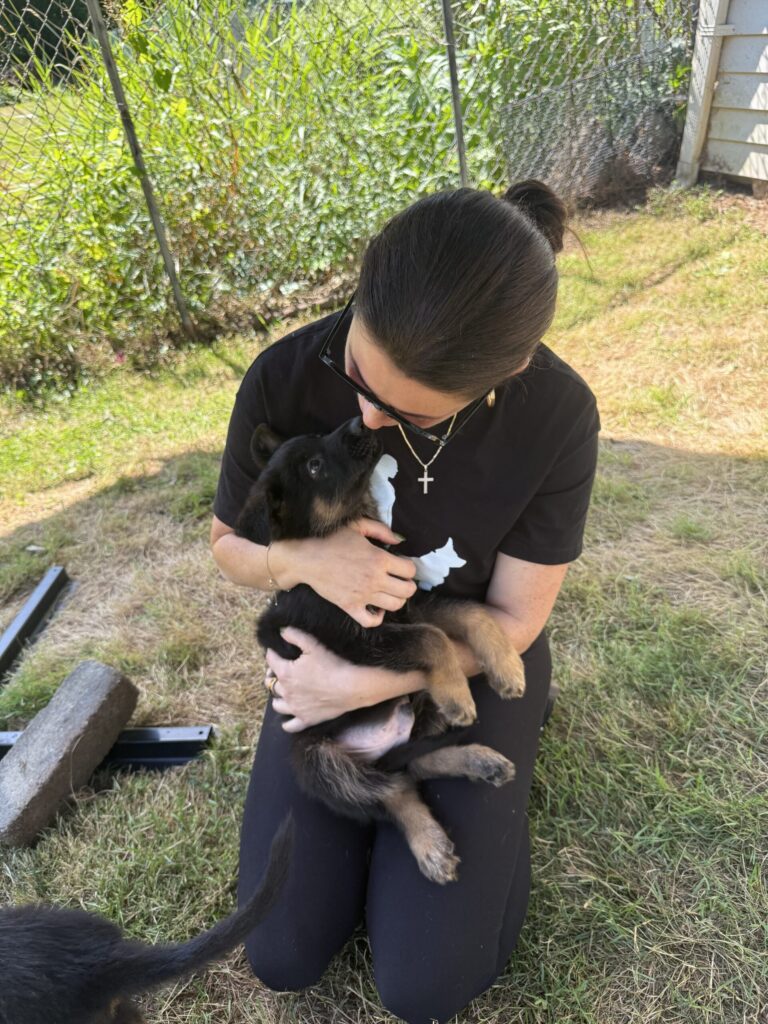 Young woman holding a German Shepherd puppy at Metro K9 Academy, Bernardsville NJ