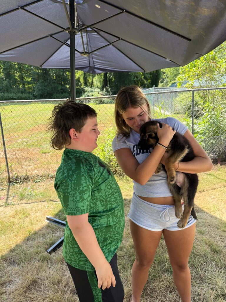 Two women with a German Shepherd puppy at Metro K9 Academy, NJ